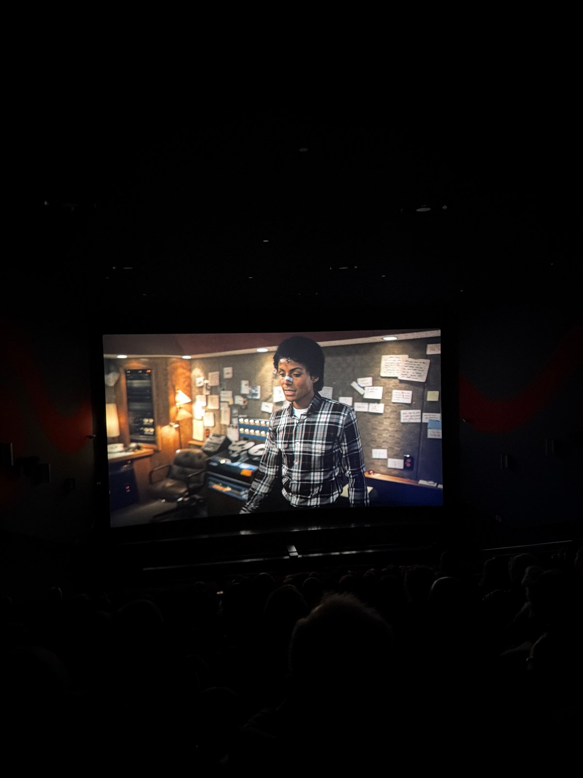 Rotated cinema screen displays film in darkened room