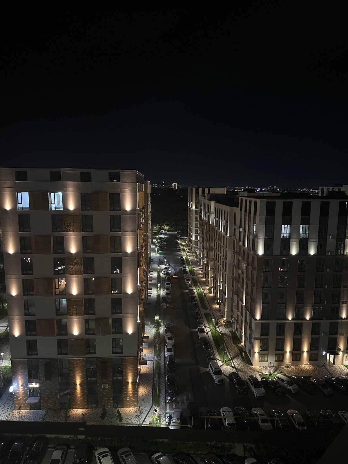 Nighttime street scene outside a modern residential complex