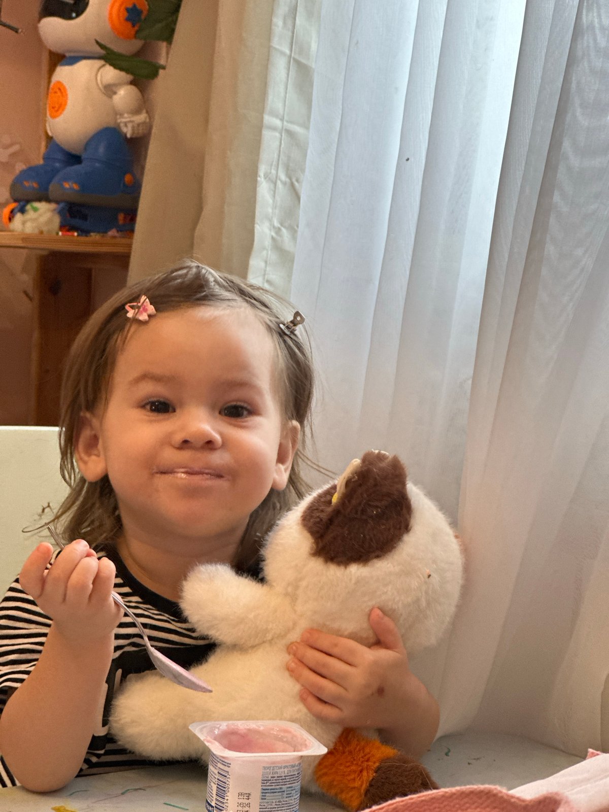 Toddler enjoys snack time with stuffed animals in Russia