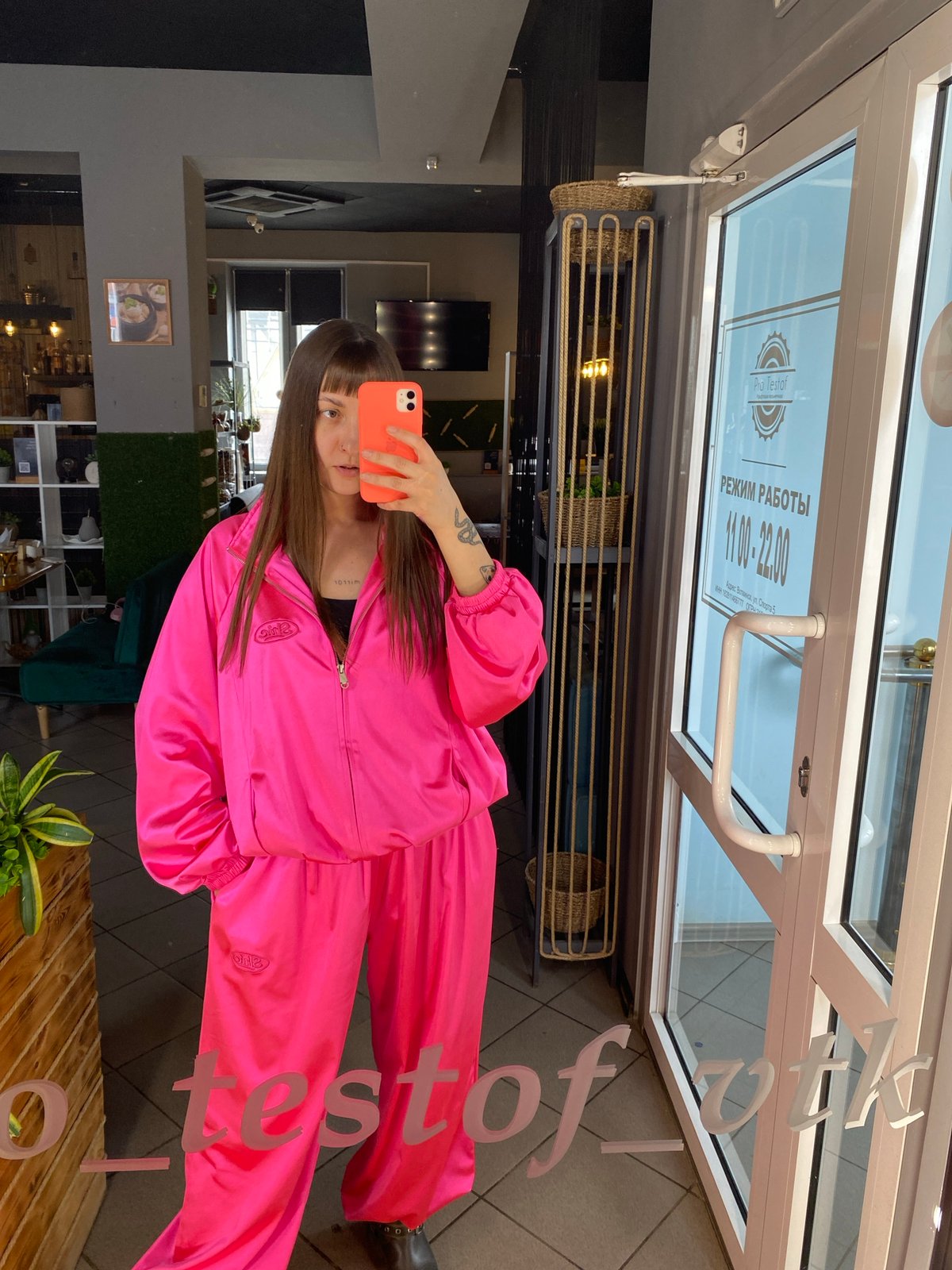 Woman in pink tracksuit dines at Votkinsk restaurant, takes selfies