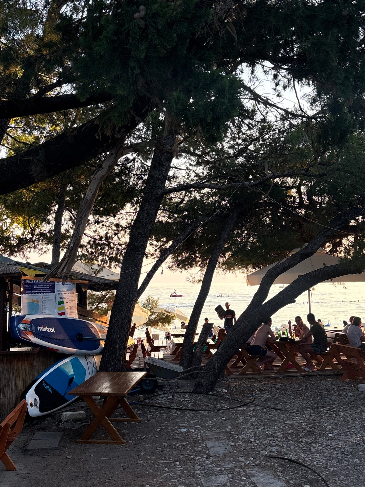 Sunset beach afternoon in Bar, Montenegro — paddleboards, volleyball, Adriatic calm