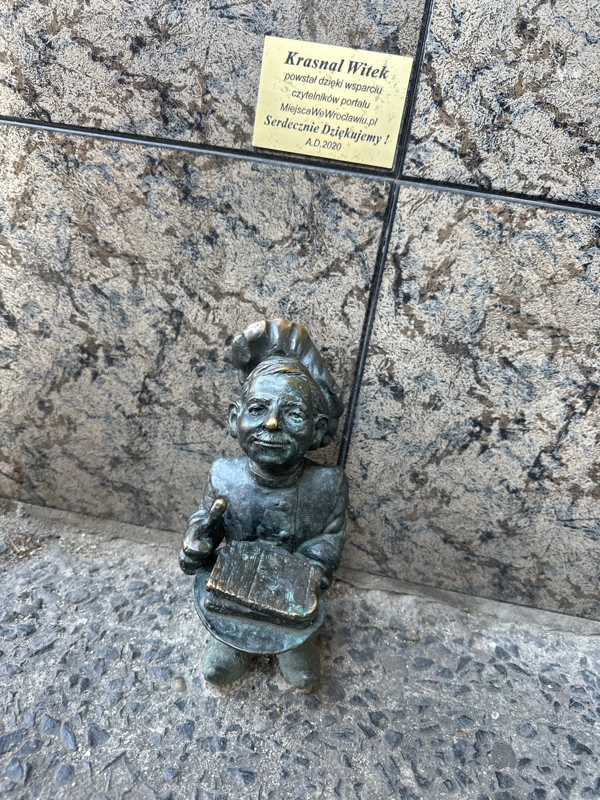Tourists photograph iconic bronze dwarfs in Wrocław historic district