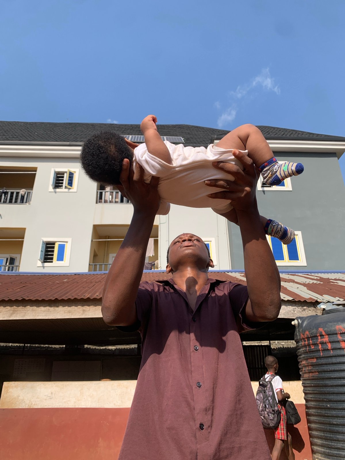 Daily life captured: father with baby, schoolchildren in Nigeria