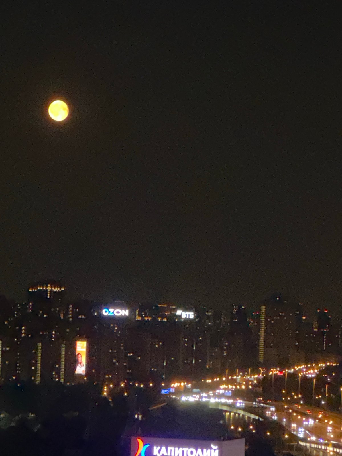 Full moon glows yellow over Khimki's lit-up urban sprawl