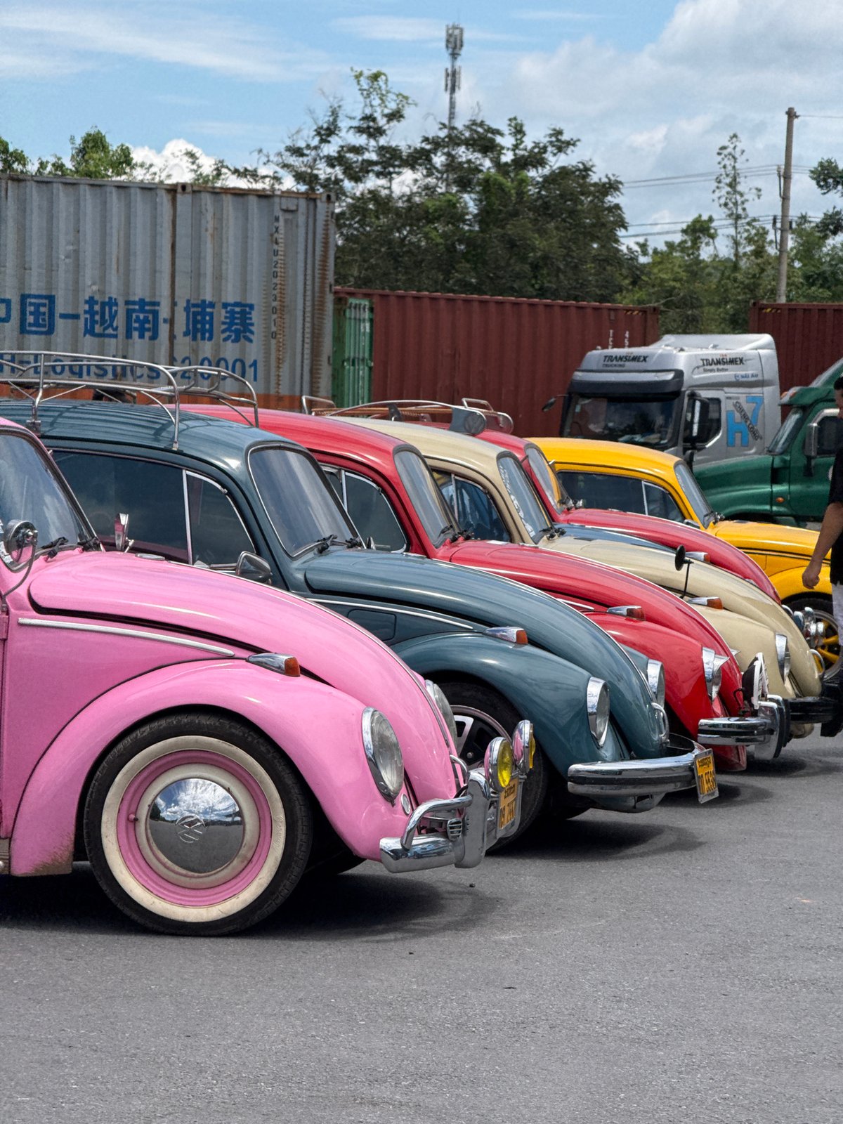 Rainbow row of vintage VW Beetles parked in Lao Bảo, Vietnam