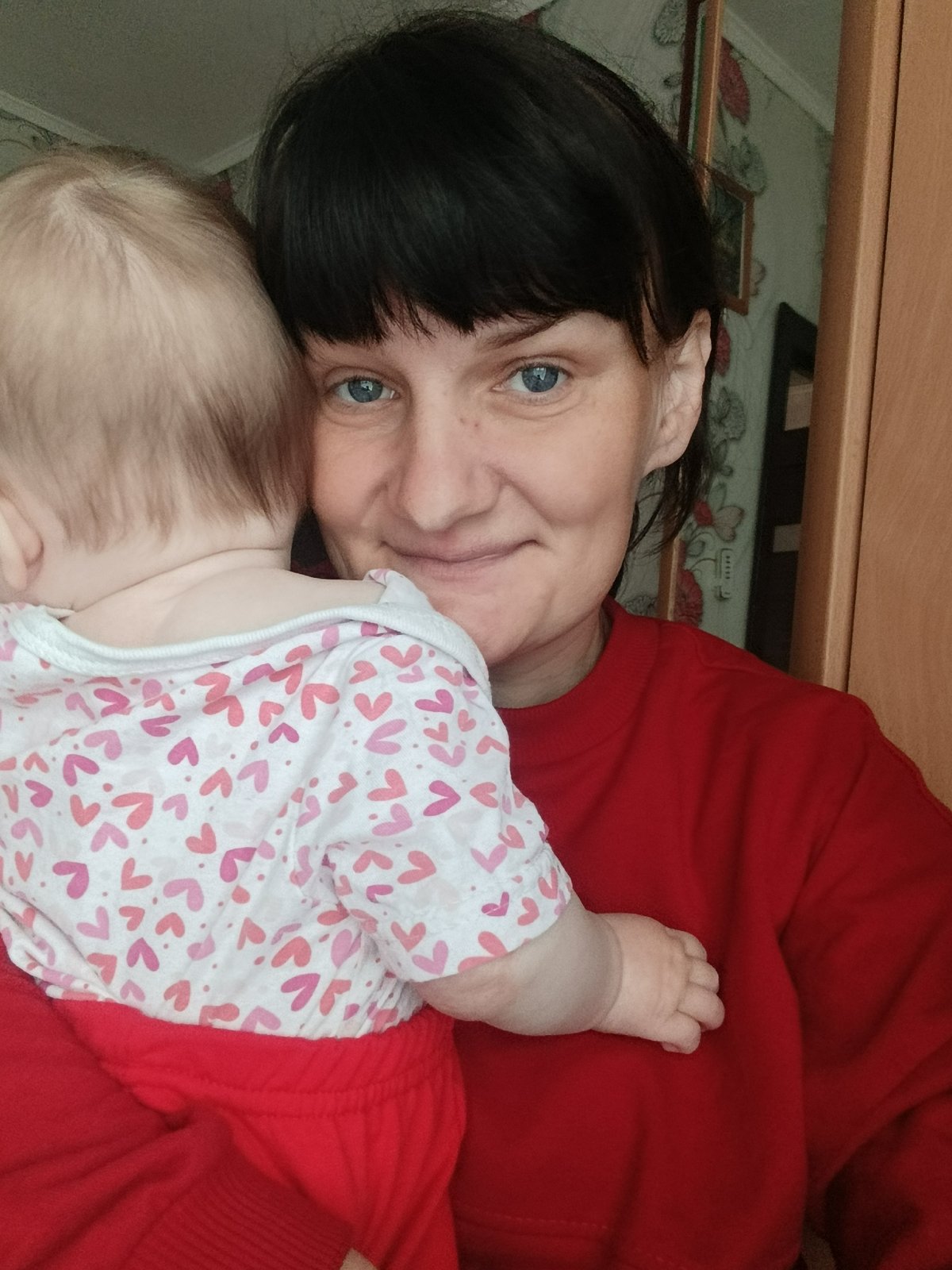 Woman holds baby in early morning moment, Foki Russia
