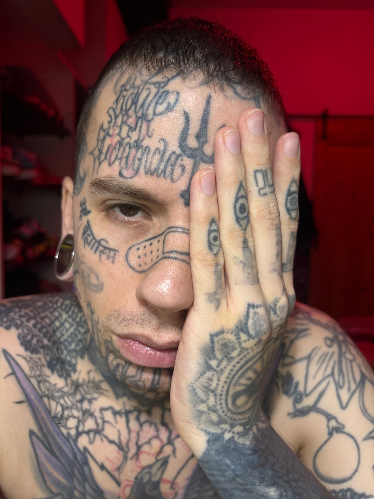 Tattooed man covers eye in Buenos Aires early morning