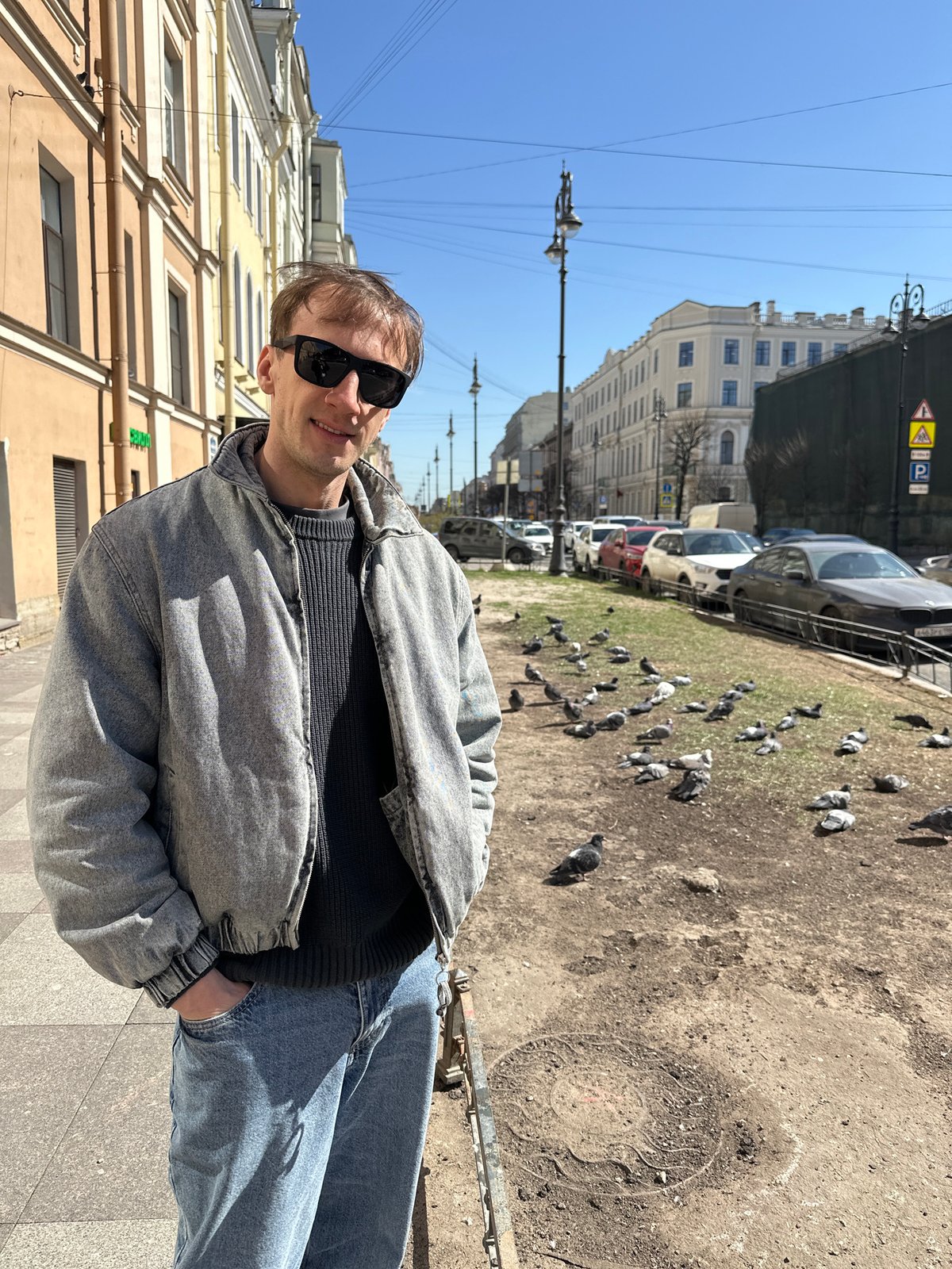 Man photographed near decaying building in sunny Saint Petersburg
