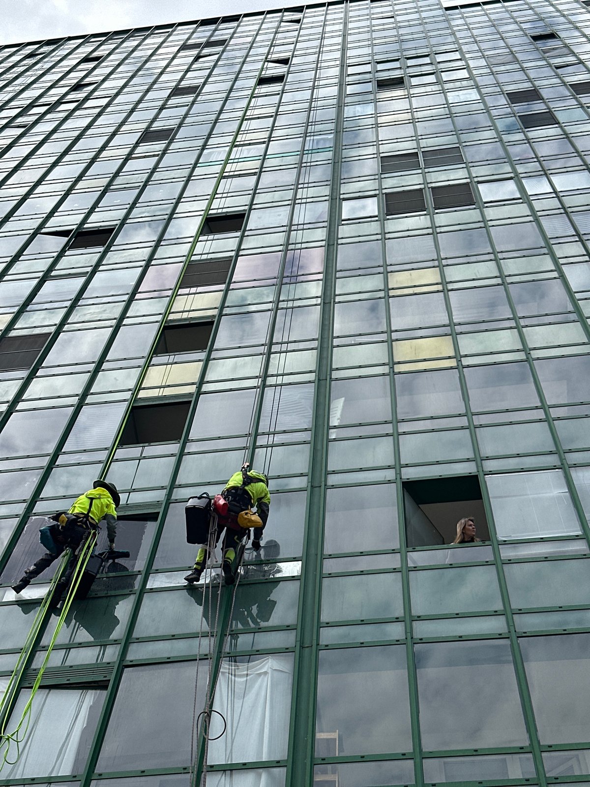 Window washers clean high-rise building facade in Murino, Russia