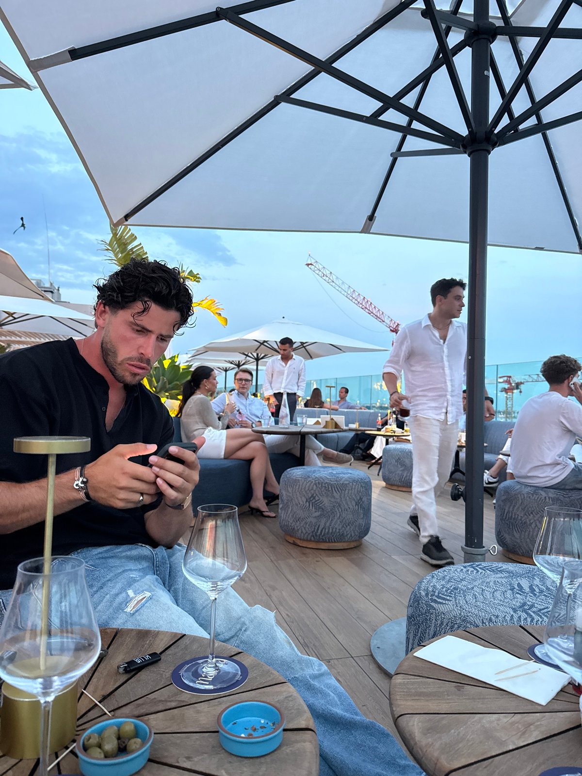 Evening rooftop gathering observed during colorful sunset in Cannes