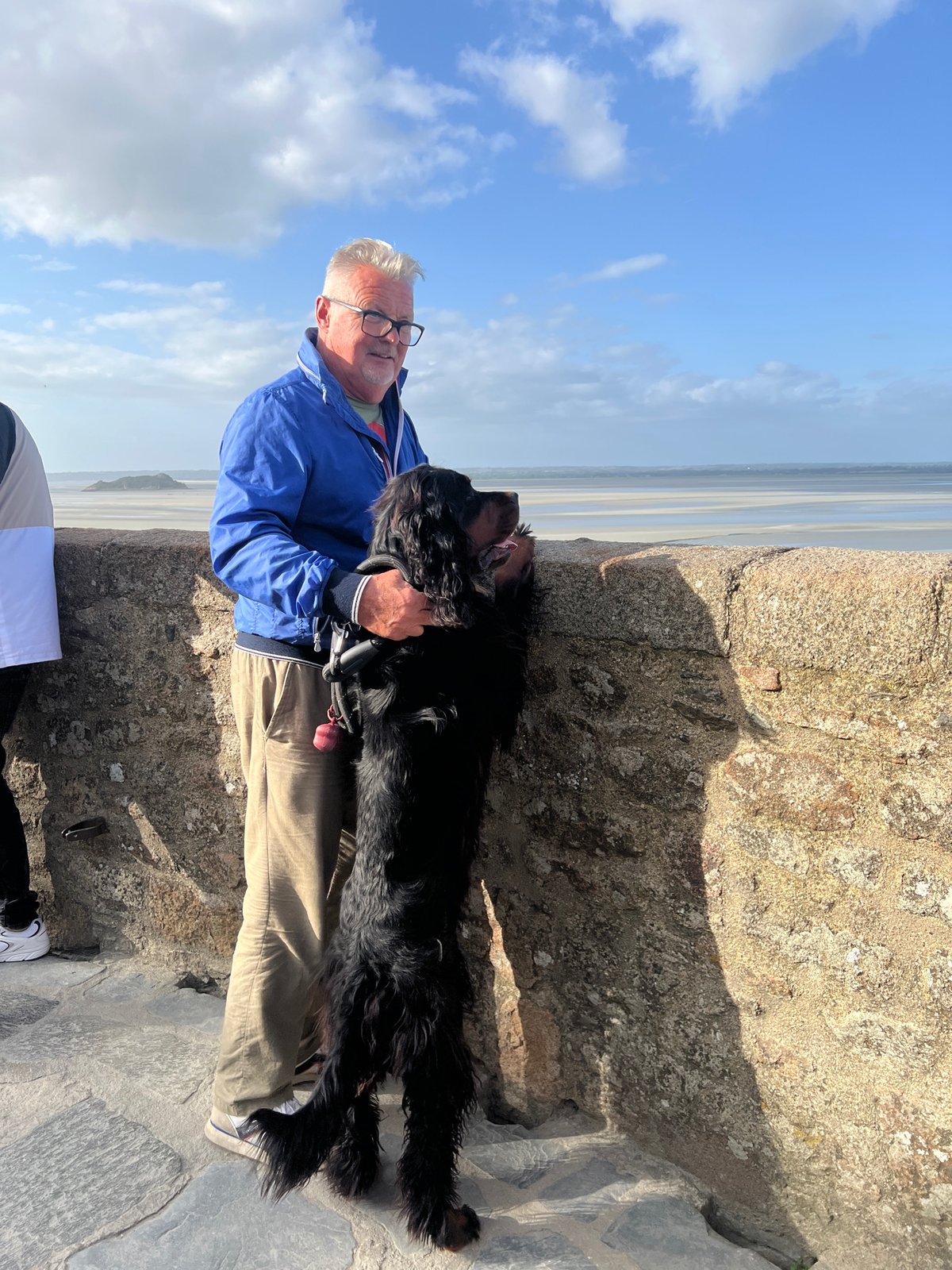 Tourists explore tidal flats at Mont-Saint-Michel during low tide