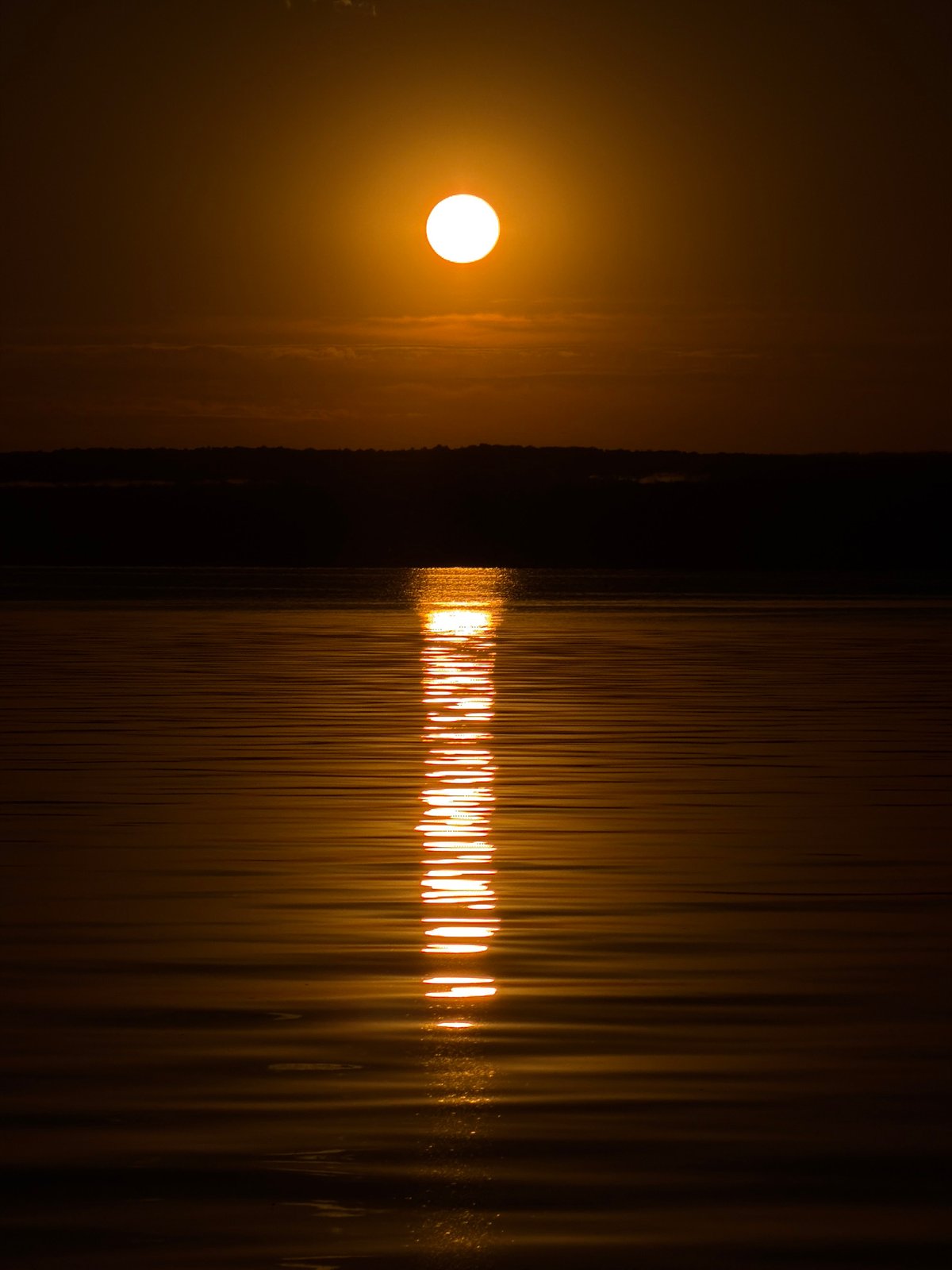 Golden sunset stretches across the water in Chaikovsky, Russia