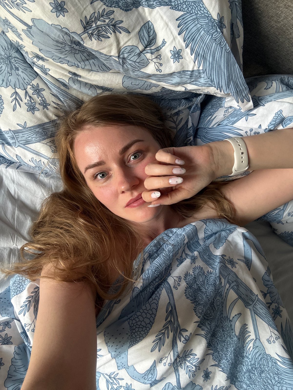 Woman photographed in bed during early morning in Saint Petersburg