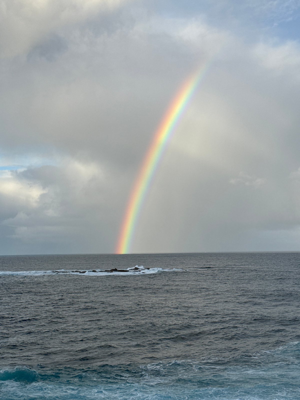 Rainbow over turbulent seas at Clovelly coast