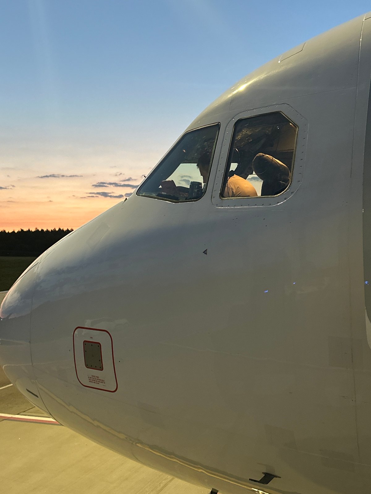 Heston Airlines flight boards at Vilnius Airport at sunset