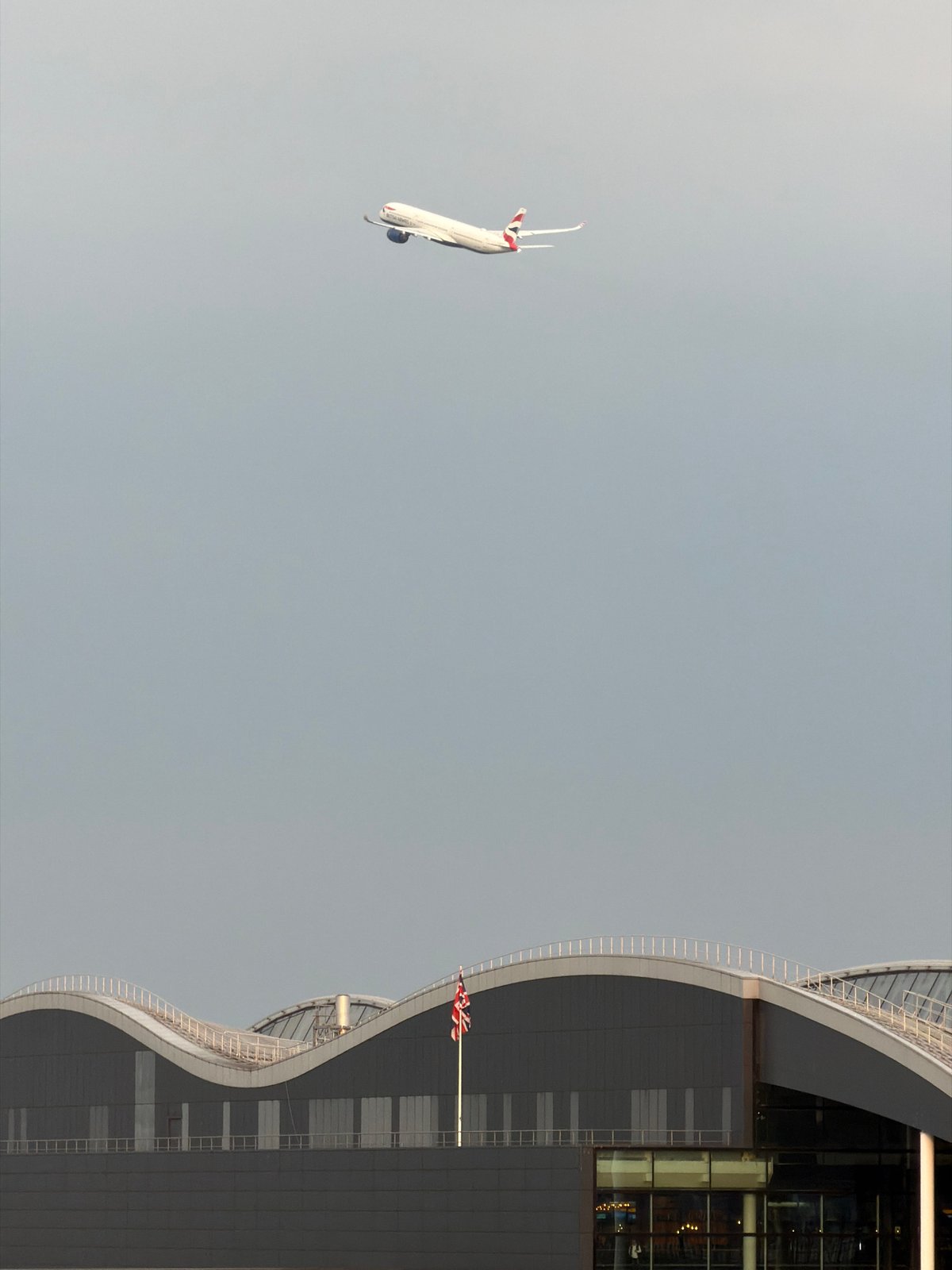 Passenger plane spotted flying past modern London building