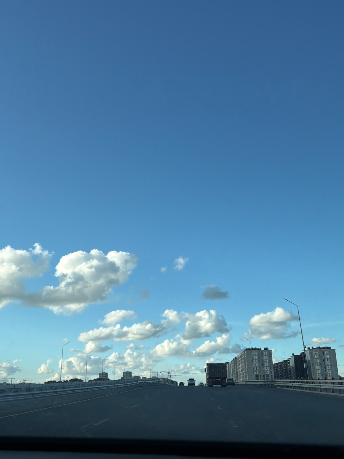 On the road through Astana, cranes and city skyline in view