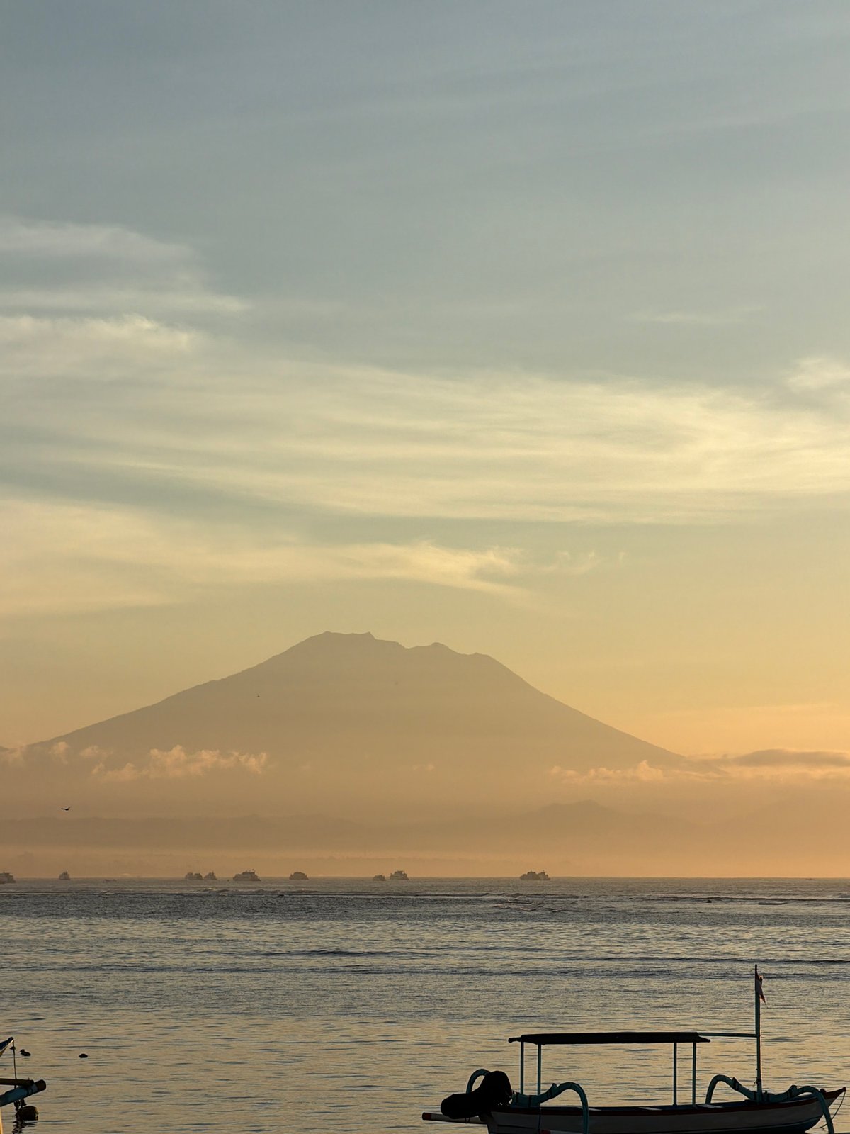 Sunset over Denpasar beach with outrigger boats offshore