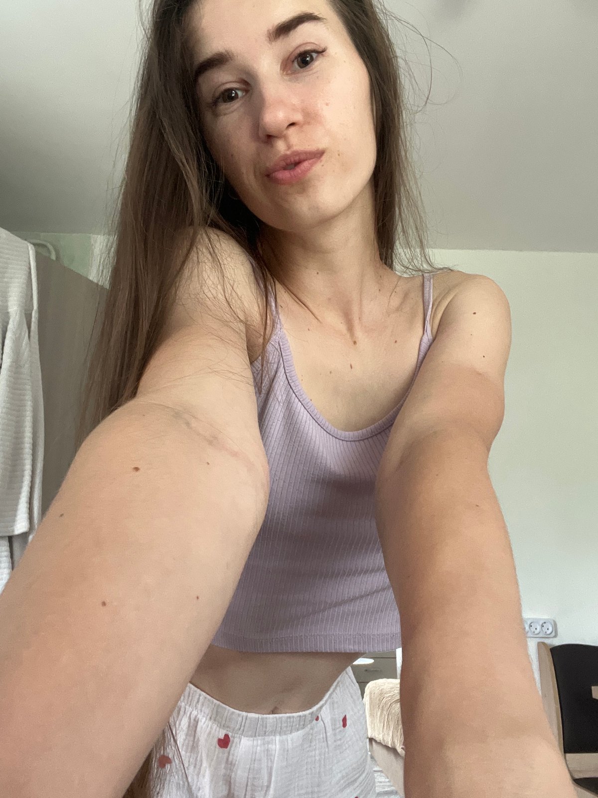 Indoor selfie session in purple top and patterned shorts