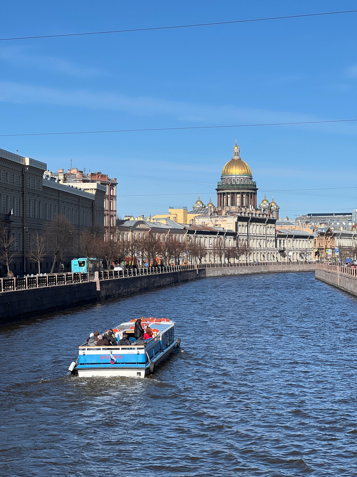 Tourist boat carries passengers past Saint Isaac's Cathedral in Petersburg