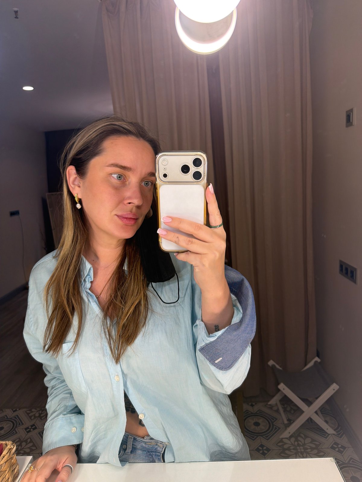 Woman takes mirror selfie with gold iPhone in Moscow