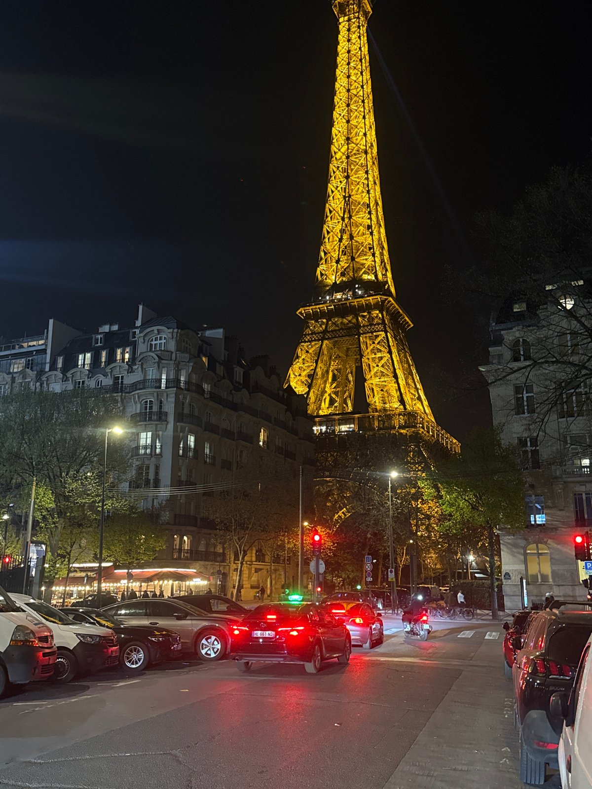 Eiffel Tower illuminated with searchlights during evening hours in Paris