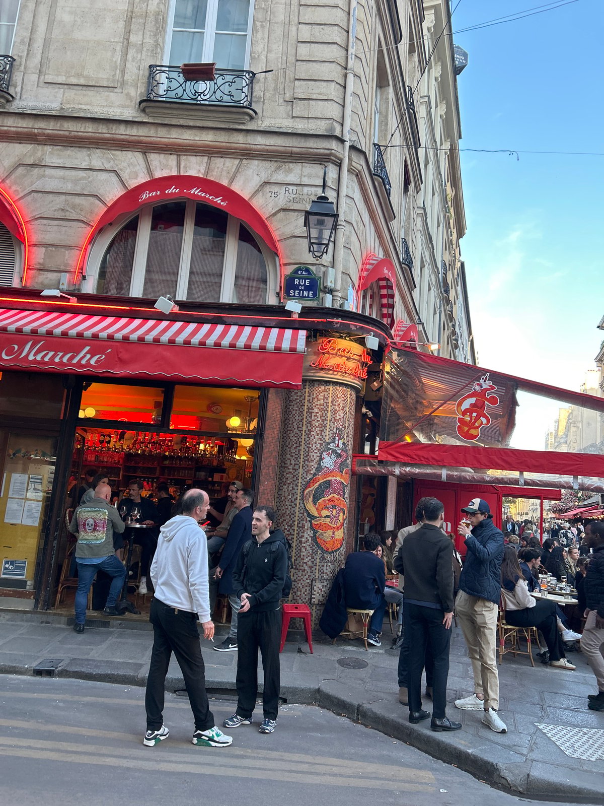 Daytime street activity captured on Rue de Seine, Paris
