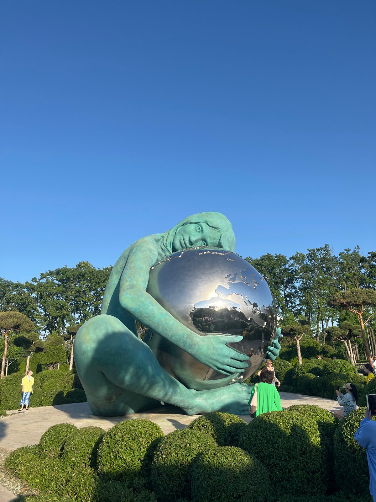 Park visitors observe Girl Holding World sculpture in Krasnodar