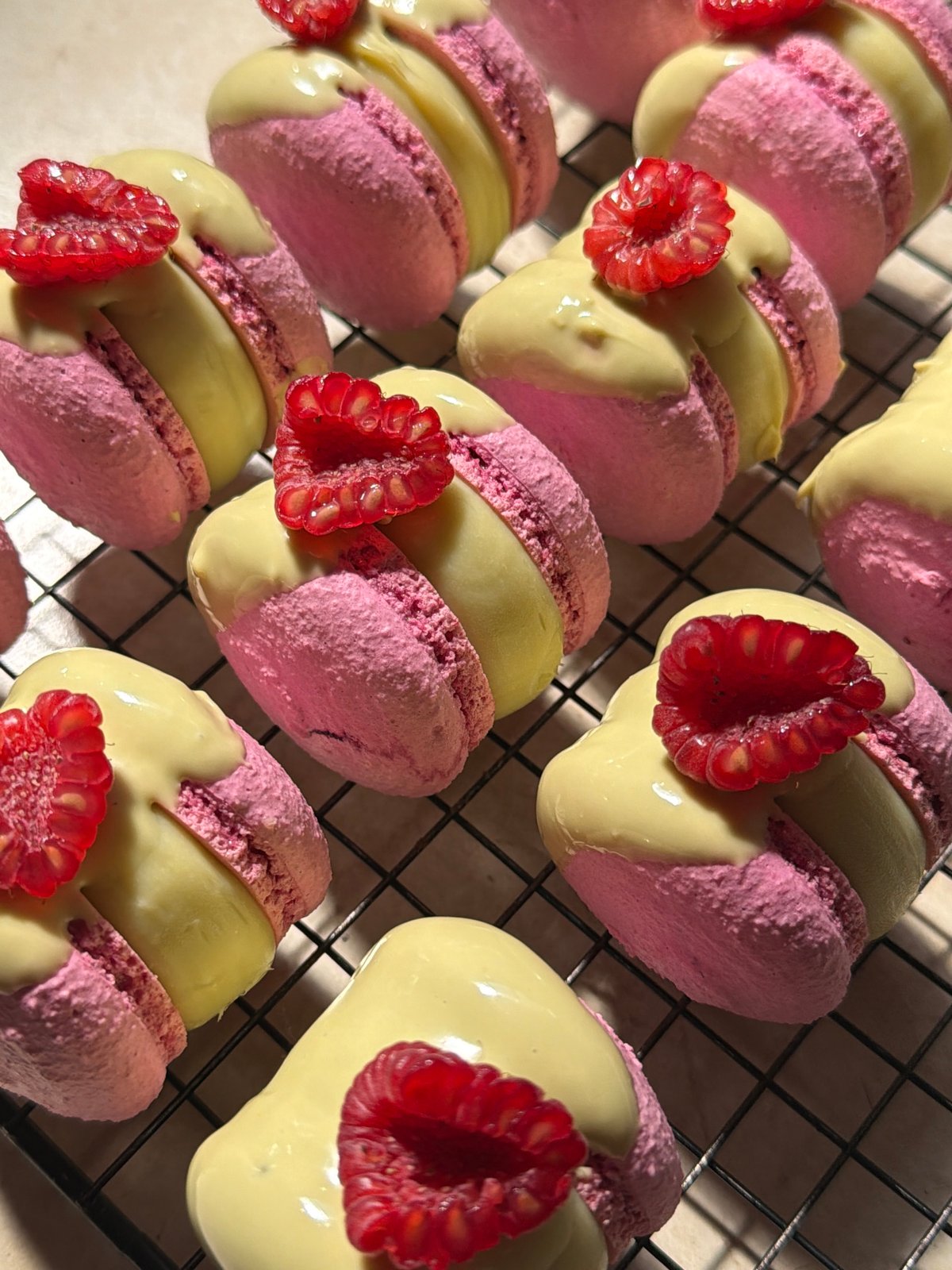 Fresh macarons and eclairs cooling on racks in Tel Aviv