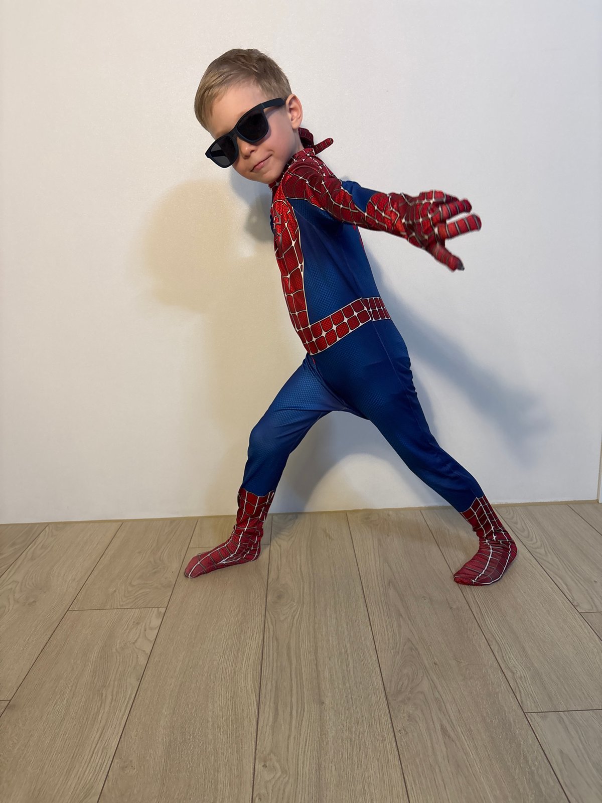 Mother and child in Spider-Man costume share playful moment indoors