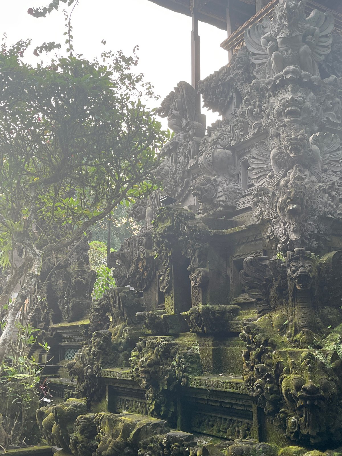 Ancient moss-covered temple carvings documented in Tegallalang, Indonesia