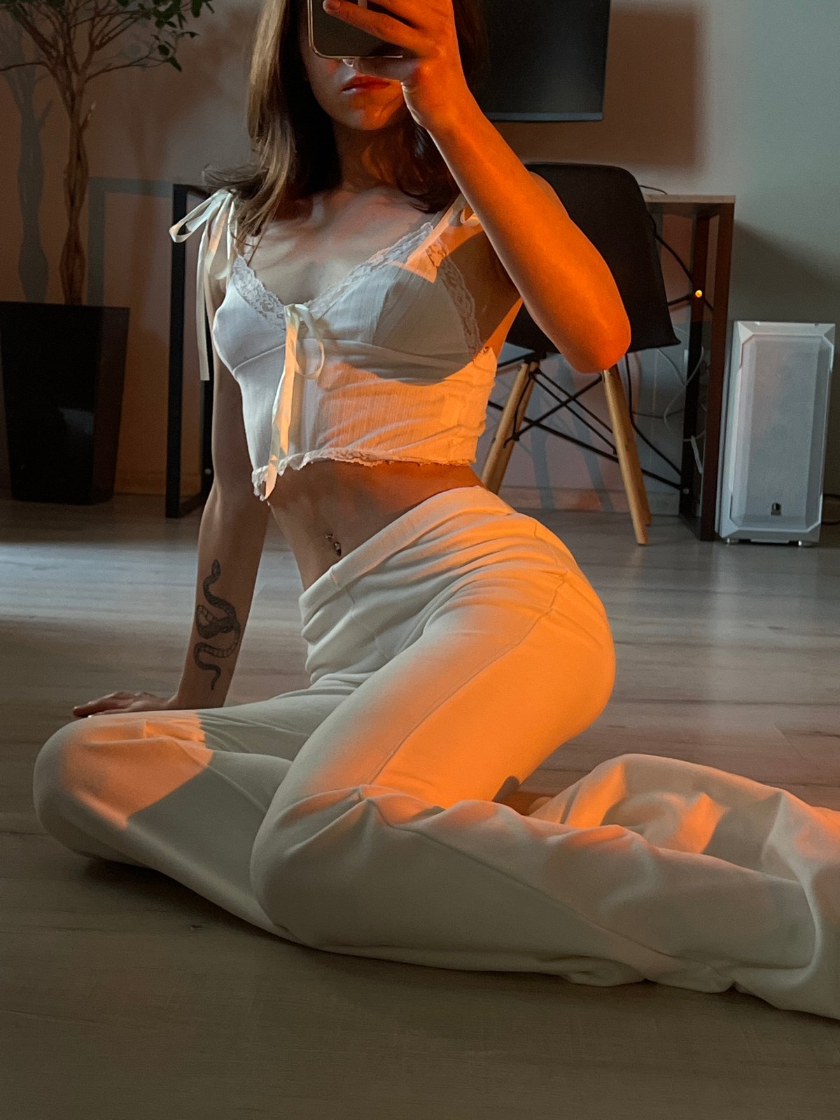 Woman takes mirror selfies in white outfit in Ternopil apartment