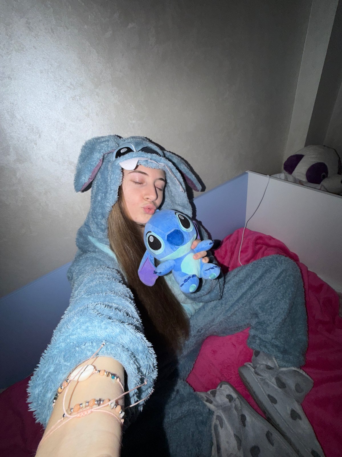 Person in Stitch onesie photographed with plush toy in Plovdiv bedroom