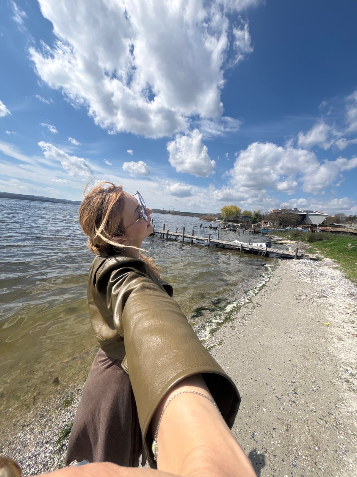 Woman photographs coastal scene with abandoned boat in Bulgaria