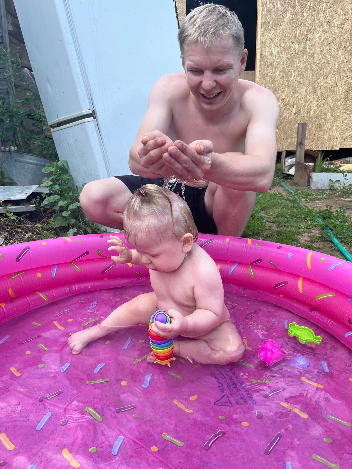 Baby plays in a sprinkle-donut kiddie pool in Fokino