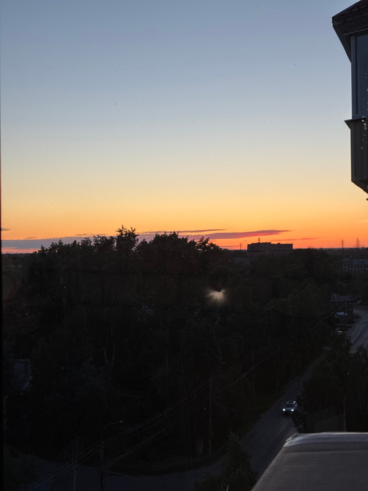 Sunset observed across city skyline during evening hours