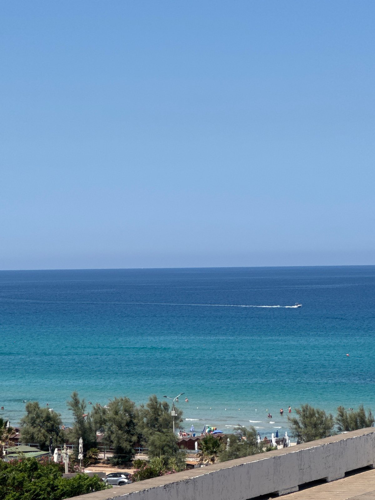 Sailboats, turquoise water, and rocky coast at Isola delle Femmine