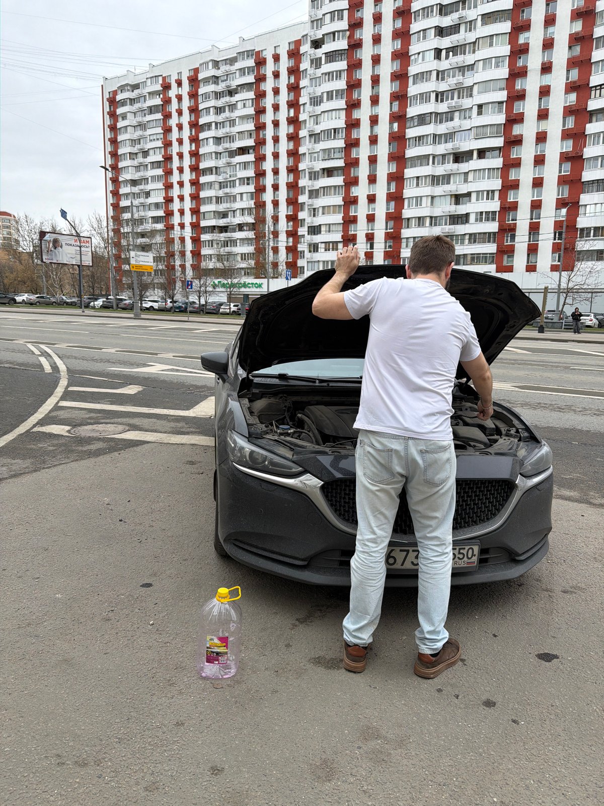 Man performs roadside car maintenance in Khimki