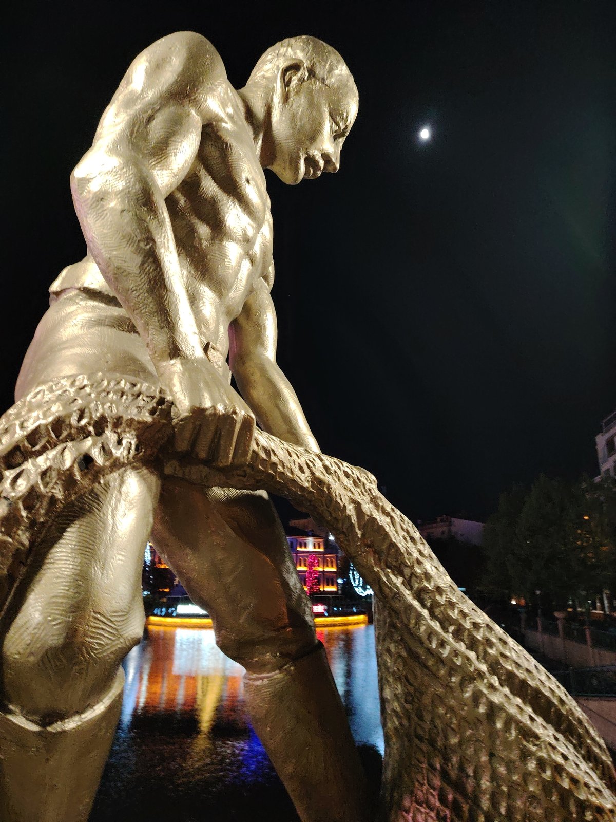 Festive lights illuminate Eskisehir waterway with golden fisherman statue