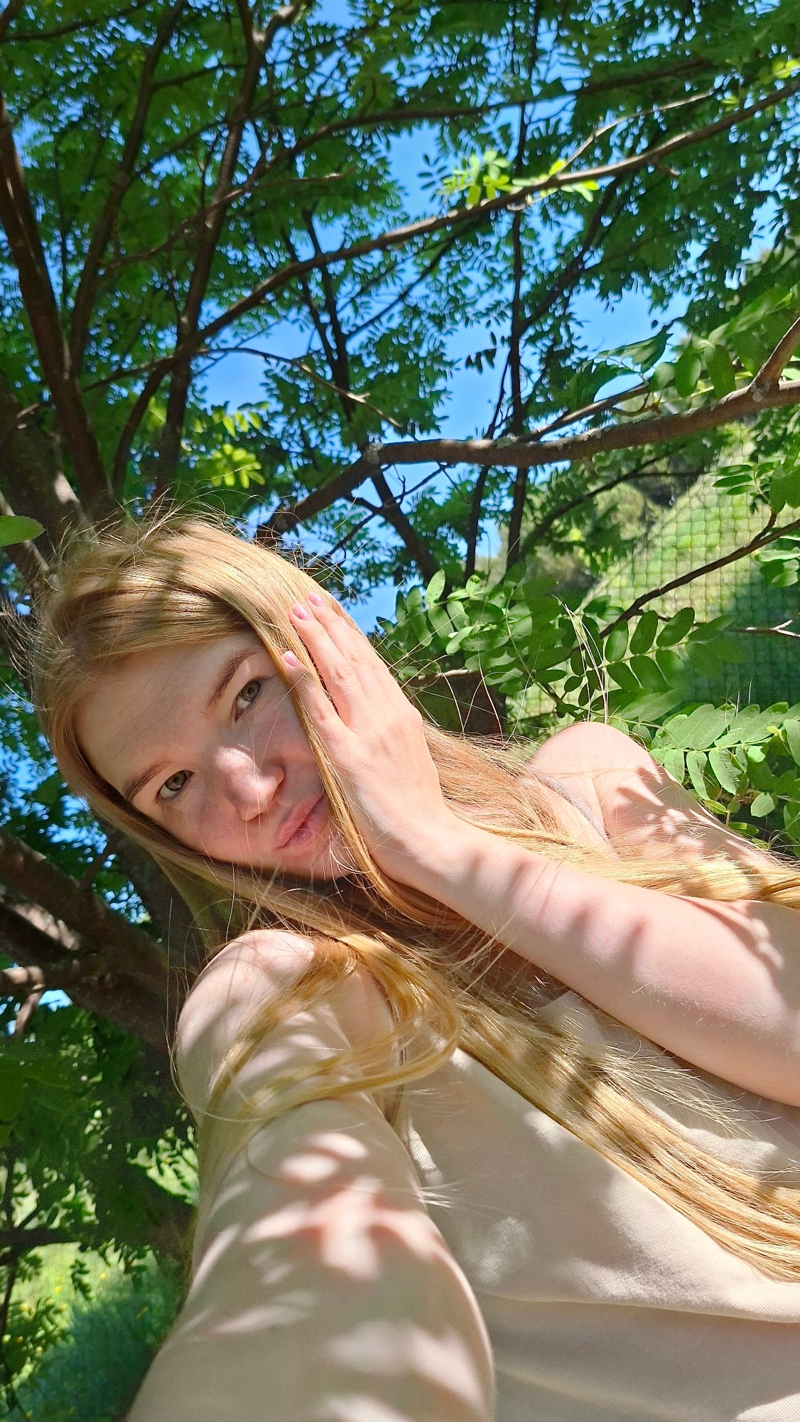 Woman documents spring morning with selfies among blooming trees