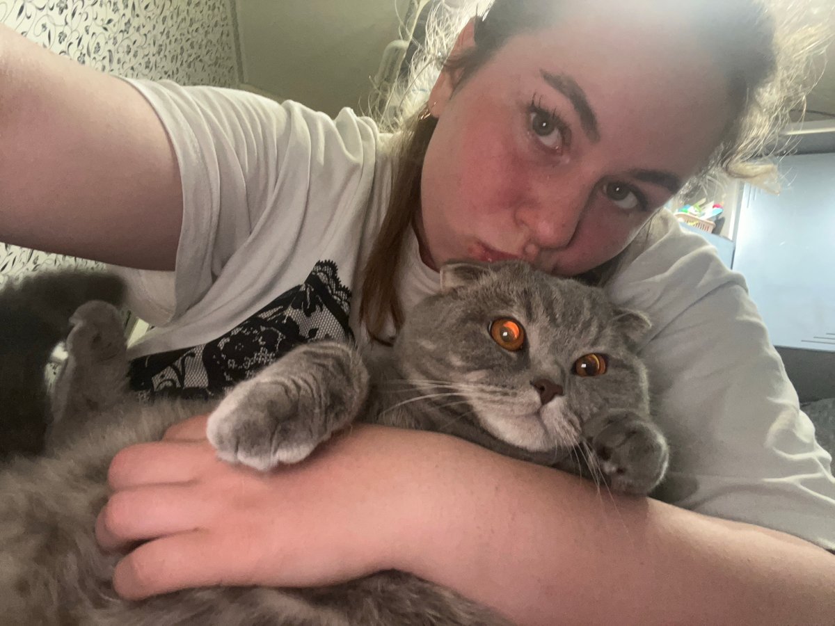 Woman shares quiet moments with grey cat in Chaikovsky