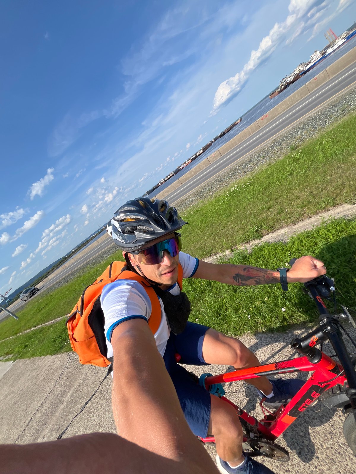 Cyclist on a red bike cruising a paved path in Chaikovsky