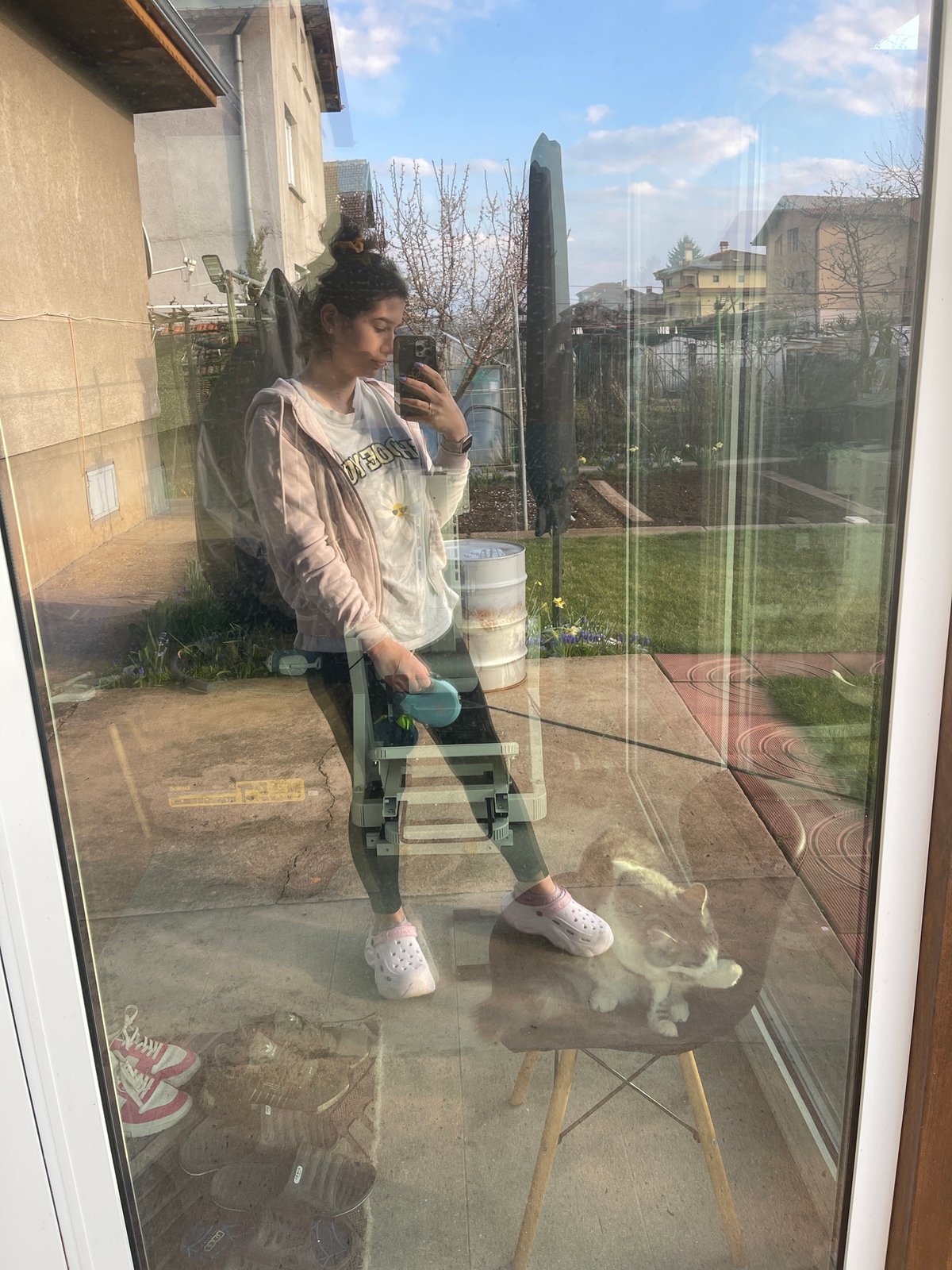 Woman photographing through reflective window in Sofia morning scene