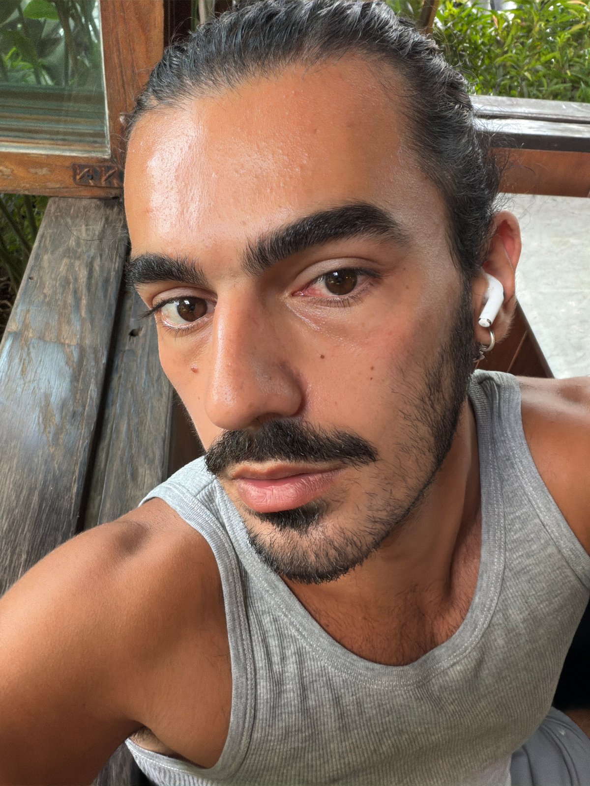 Man takes selfie on wooden bench in North Kuta