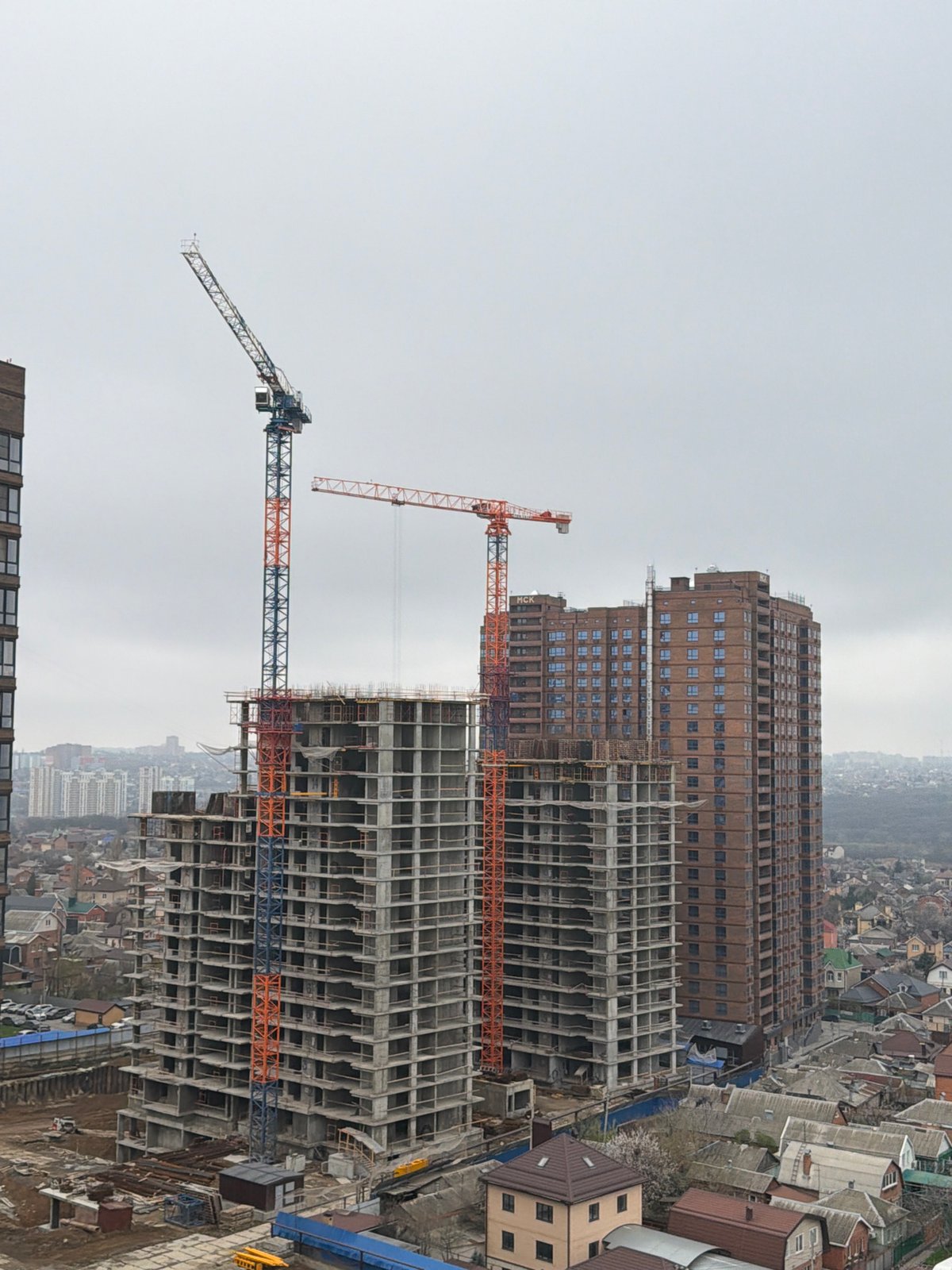 Woman photographs Rostov-on-Don construction from balcony overlook