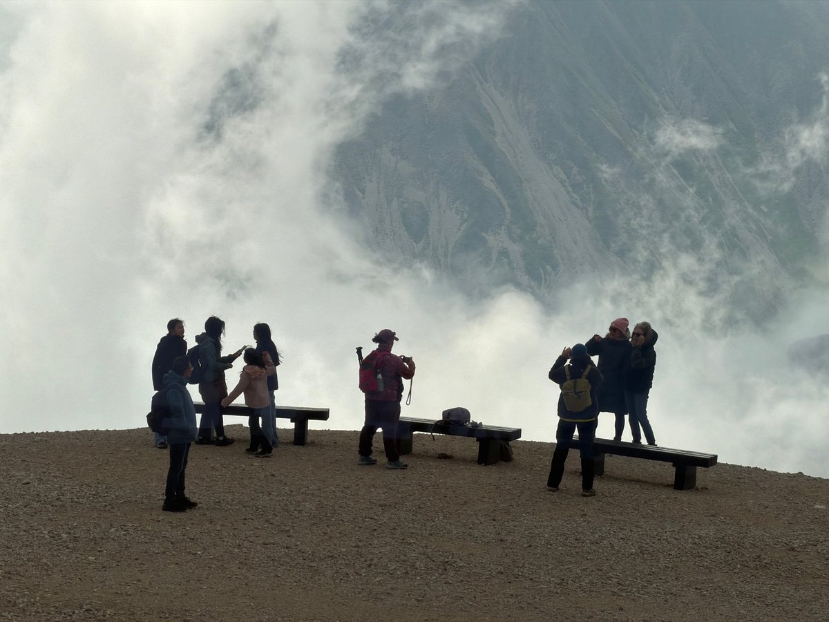 Hikers on a cloudy ridge in the Austrian Alps