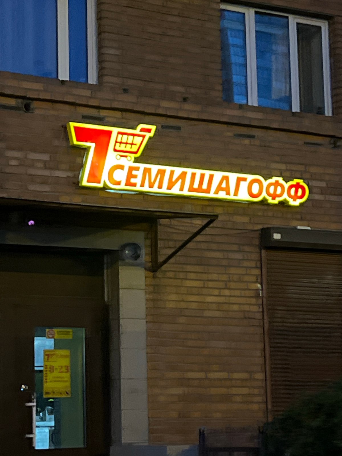 Dusk falls on a Ladozhskoe Ozero street, neon sign glowing