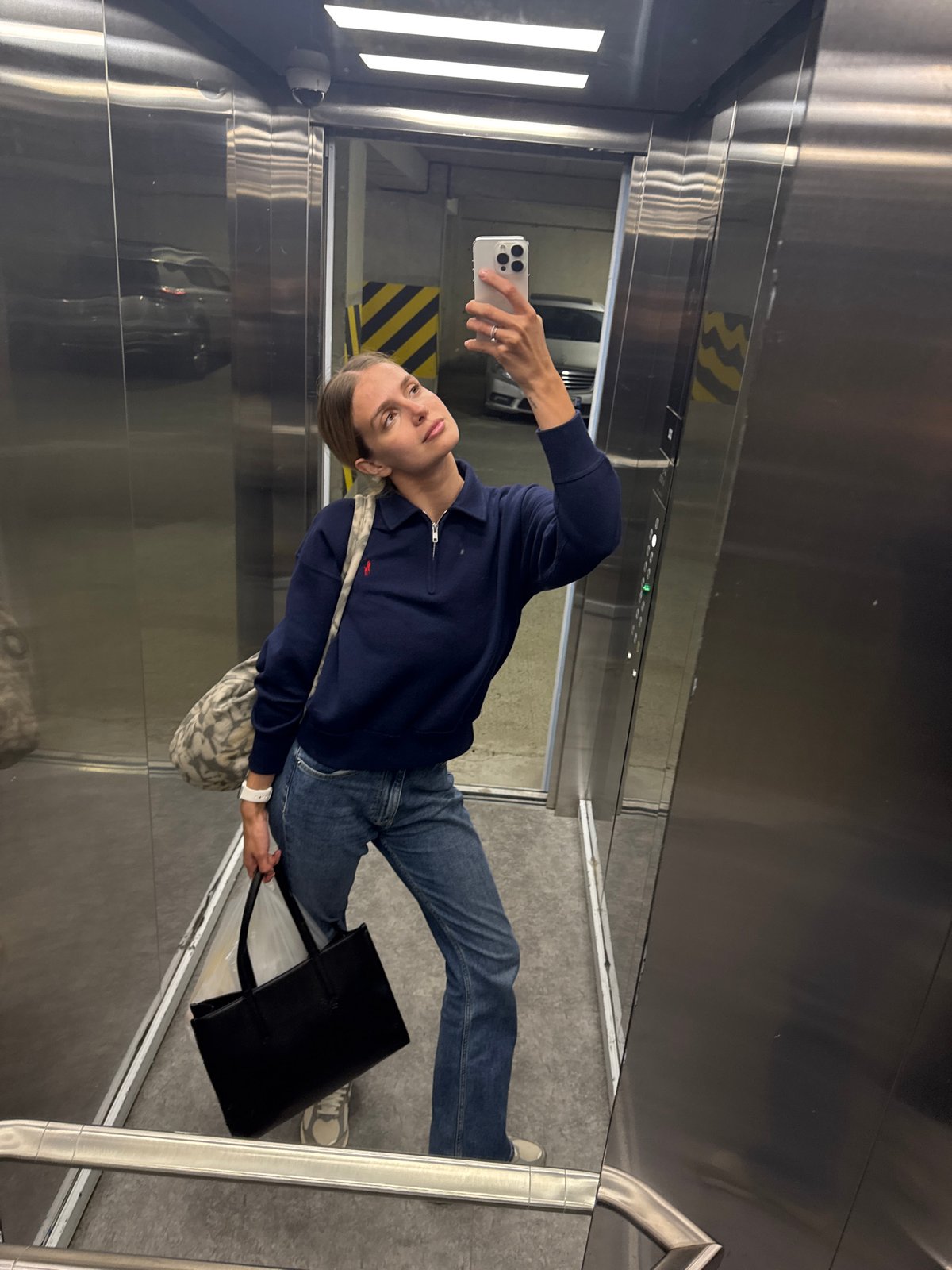 Woman takes elevator selfies in stainless steel cabin