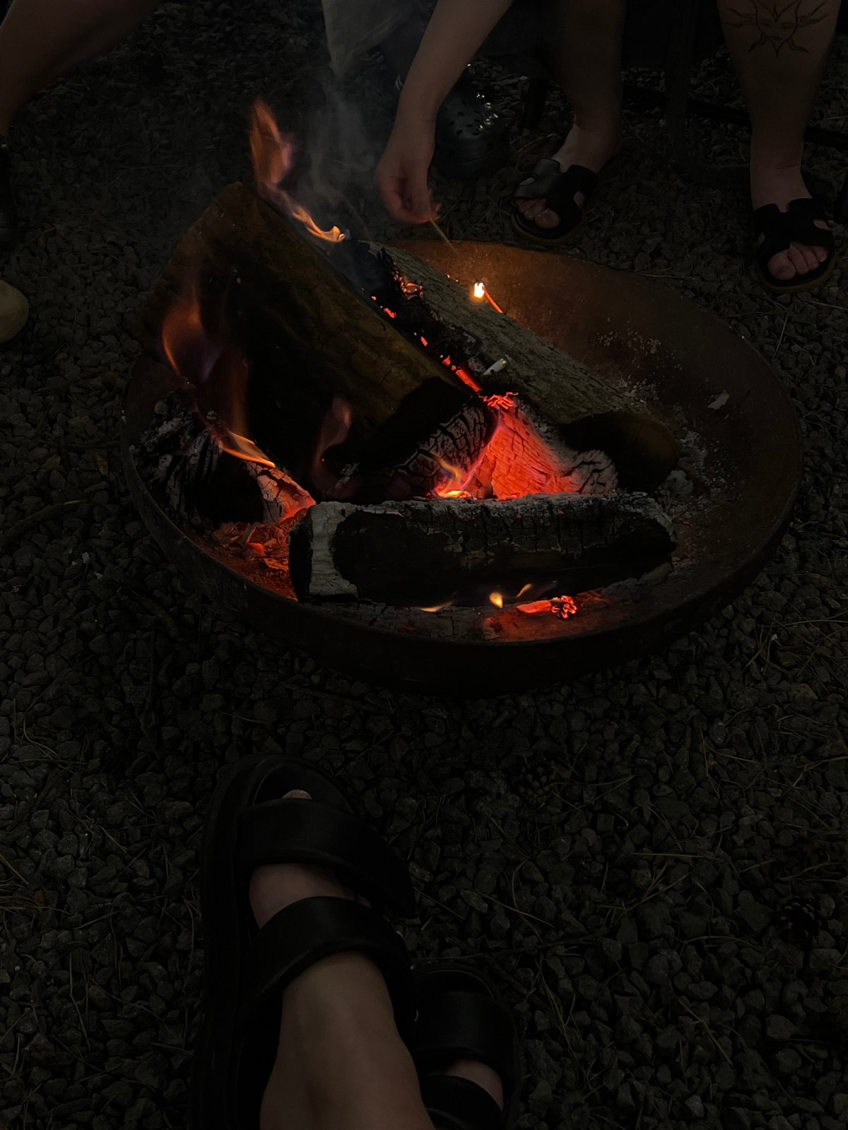 Backyard night in Ivachiv Horishnii: fire, grill, pool, people.