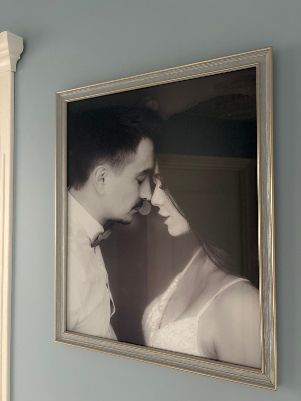 Vintage couple's photograph observed on blue wall
